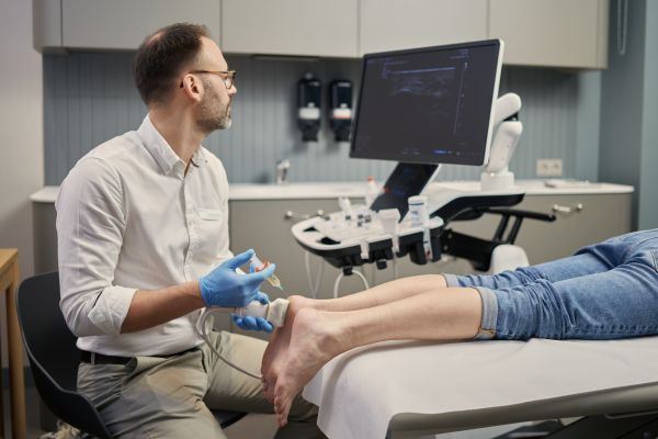 Dr Paśnik wykonuje iniekcję do kolana pod kontrolą ultrasonografii w czasie rzeczywistym Synovia Warszawa