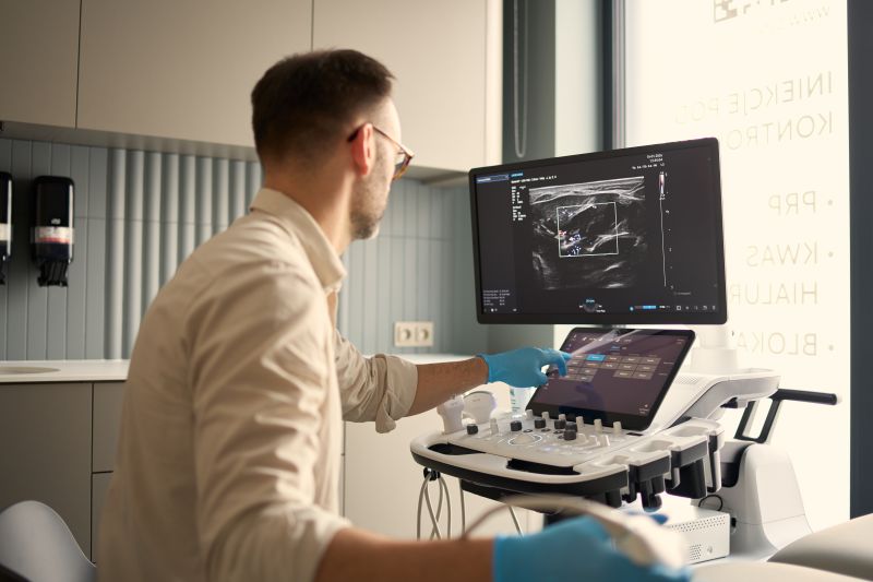 Lekarz radiolog wykonujący badanie USG ortopedyczne przy stanowisku diagnostycznym w klinice Synovia w Warszawie