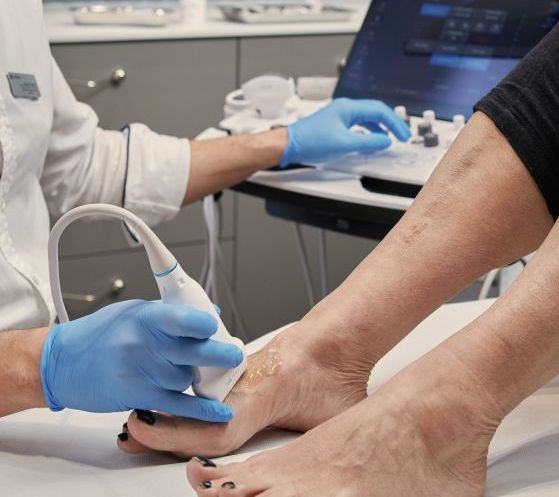 Lekarz wykonujący badanie USG stopy w gabinecie Synovia Warszawa