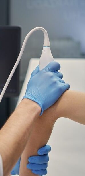 Lekarz wykonujący badanie USG stawu łokciowego w gabinecie Synovia