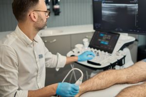 Lekarz wykonujący badanie USG mięśni i ścięgien w gabinecie Synovia Warszawa