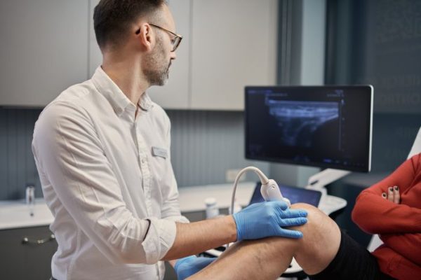 Lekarz radiolog wykonuje badanie USG kolana w Gabinecie Synovia Warszawa - diagnostyka ultrasonograficzna