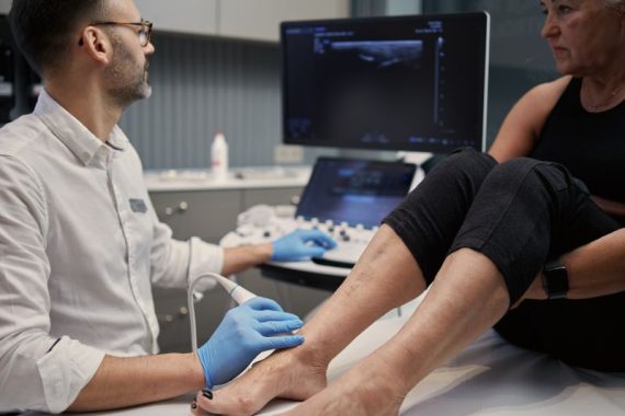 Lekarz wykonujący badanie USG stawu skokowego w gabinecie Synovia Warszawa